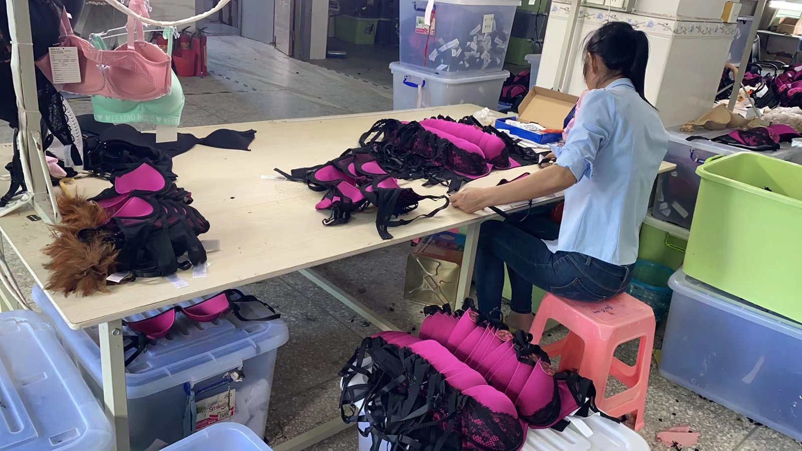 alt with keywords: A quality control inspector checking the seams on a bra in a factory