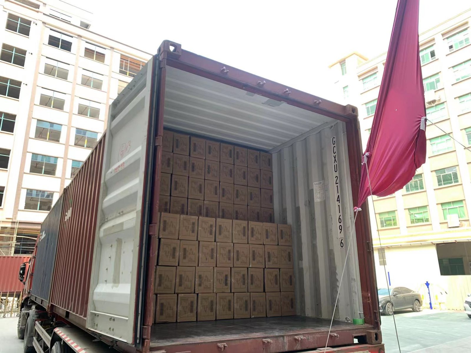 Smart Lingerie Sourcing Strategies alt with keywords: A shipping container and a factory, symbolizing the total landed cost